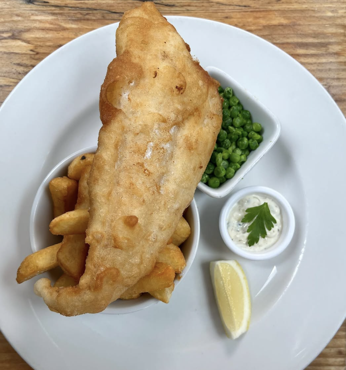 Beer-battered fish and chips with mushy peas, tartar sauce and lemon